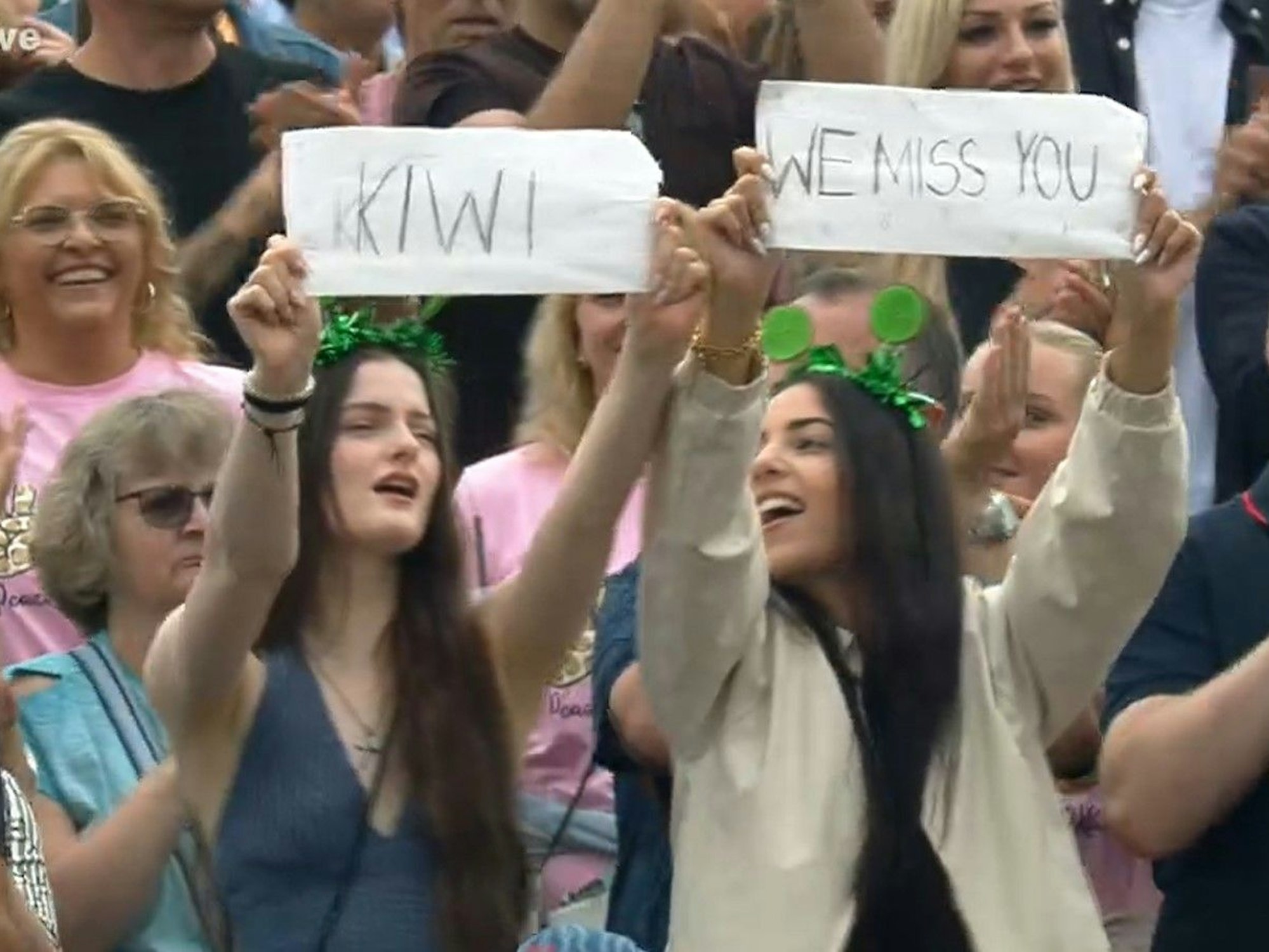 Mit selbstgeschriebenen Zetteln teilen diese Zuschauerinnen mit, dass sie die Moderatorin vermissen.