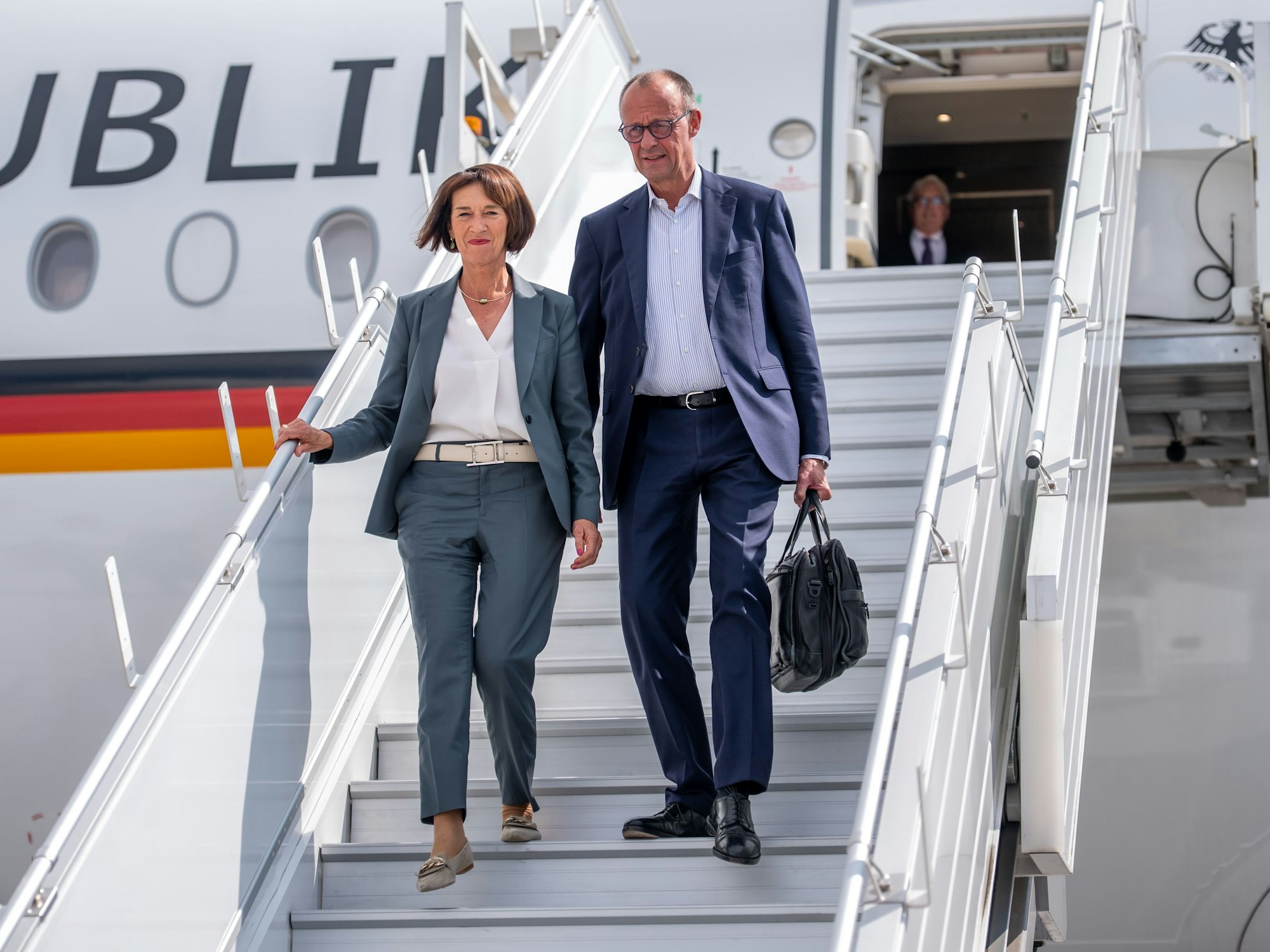 Friedrich und Charlotte Merz steigen aus einem Flugzeug.