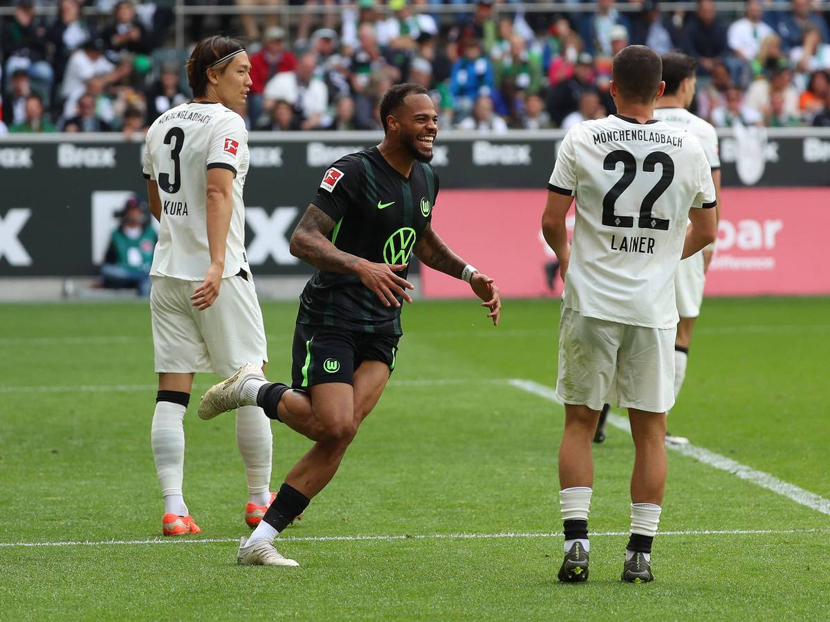 Wolfsburgs Lukas Nmecha jubelt im Spiel bei Borussia Mönchengladbach, Ko Itakura und Stefan Lainer sind bedient.