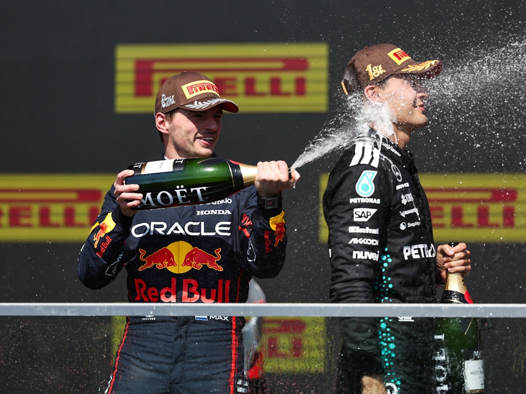 Max Verstappen besprüht Kanada-Gewinner George Russell auf dem Podium mit Sekt.