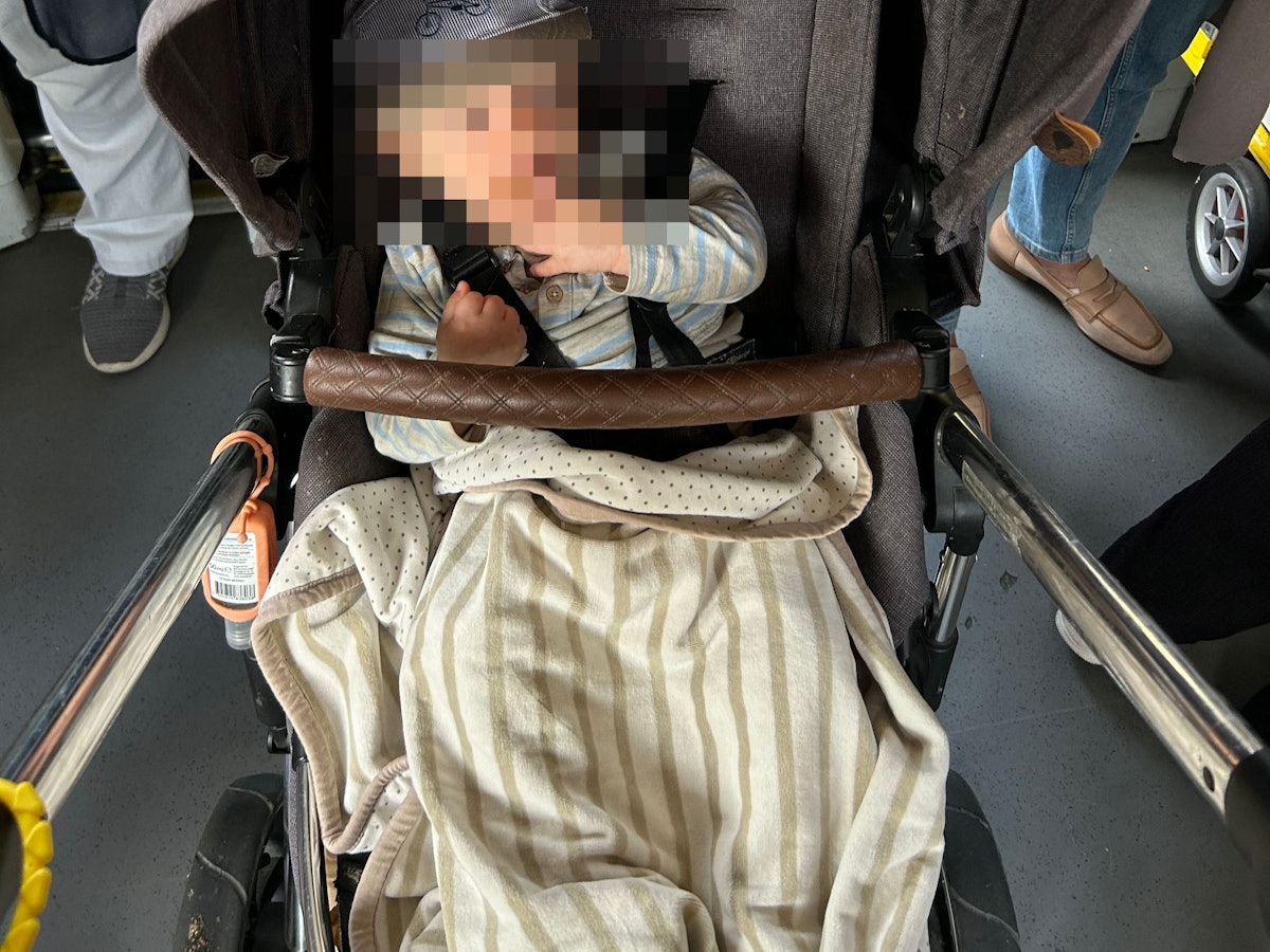 Ein Kind sitzt in einem Kinderwagen.