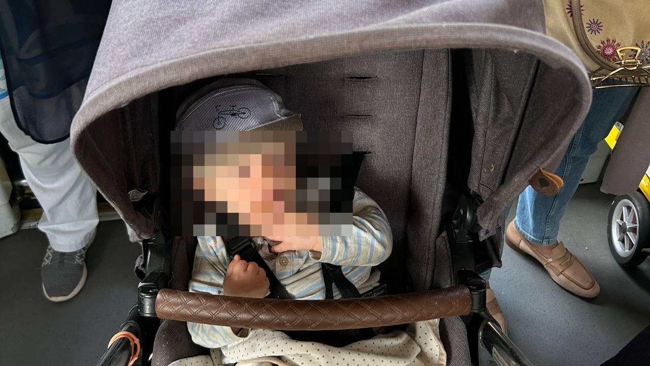 Ein Kind sitzt in einem Kinderwagen.