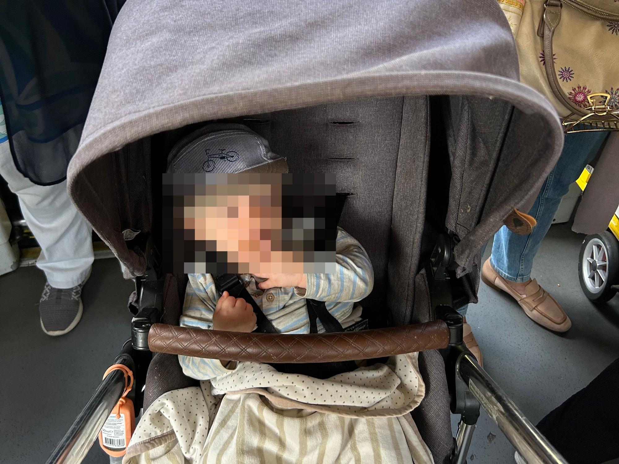 Ein Kind sitzt in einem Kinderwagen.