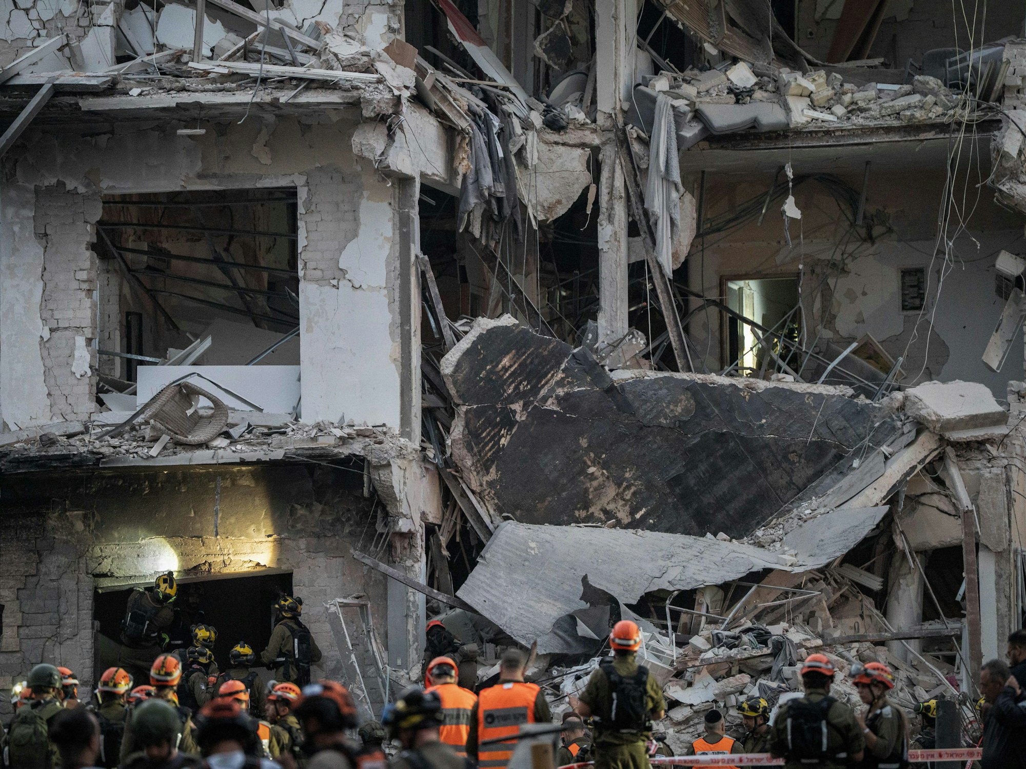 Israelische Rettungskräfte durchsuchen ein zerstörtes Gebäude nach einem iranischen Raketenangriff auf das Zentrum von Tel Aviv.