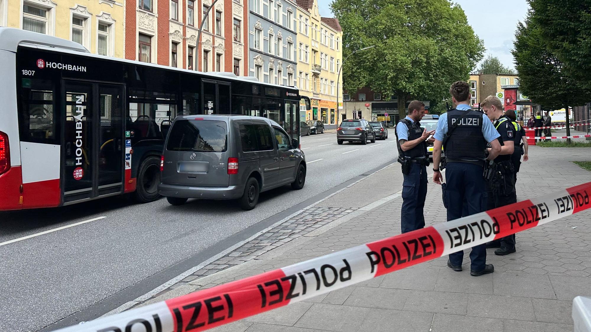 Hinter einer Absperrung stehen Polizisten vor einem Linienbus. Bei einer tätlichen Auseinandersetzung in dem Hamburger Bus, bei der auch ein Messer im Spiel war, hatte es zuvor Verletzte gegeben.
