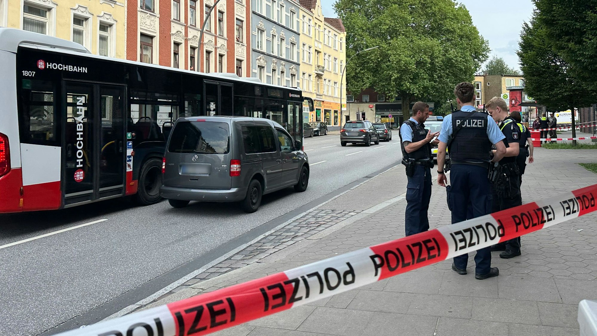 Hinter einer Absperrung stehen Polizisten vor einem Linienbus. Bei einer tätlichen Auseinandersetzung in dem Hamburger Bus, bei der auch ein Messer im Spiel war, hatte es zuvor Verletzte gegeben.