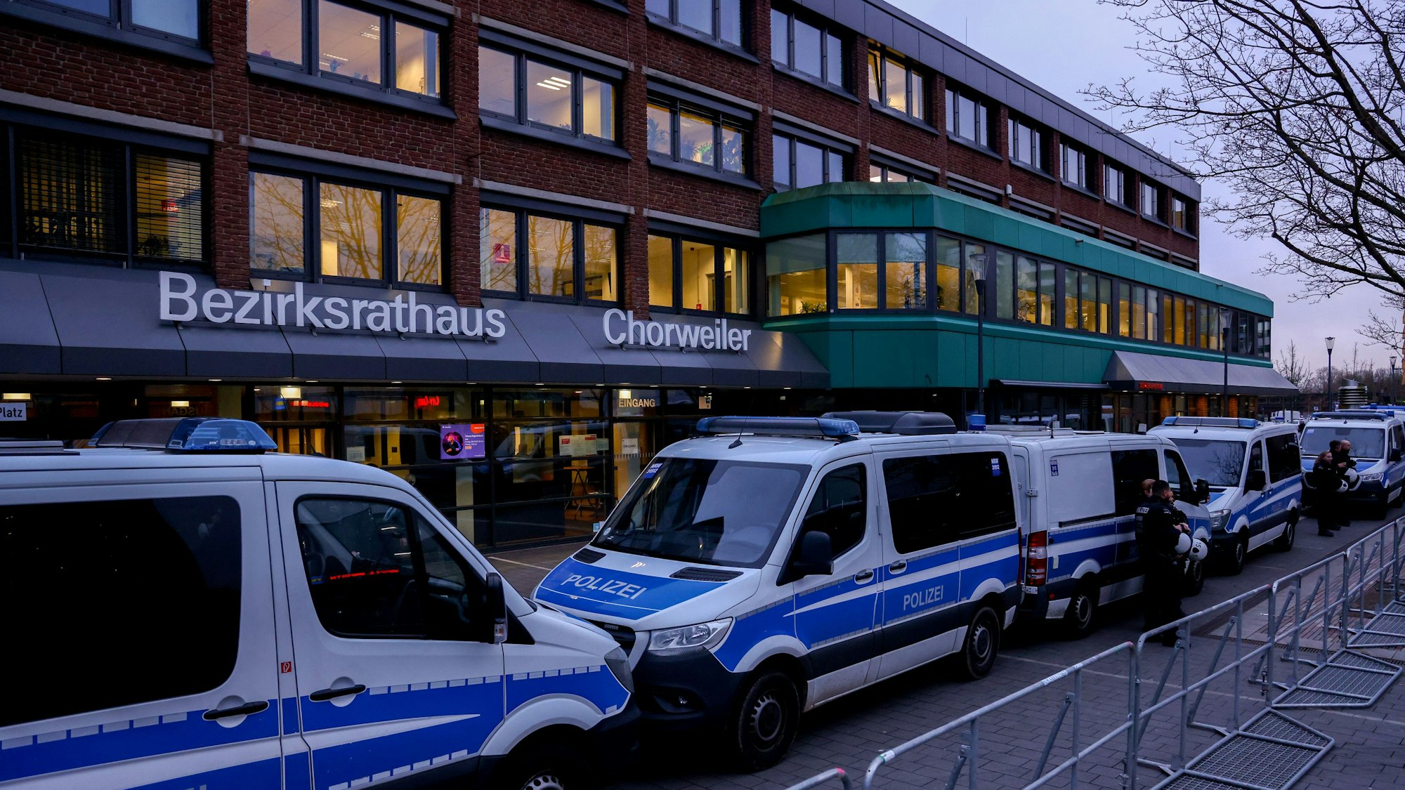 Polizeifahrzeuge stehen vor einem Gebäude.