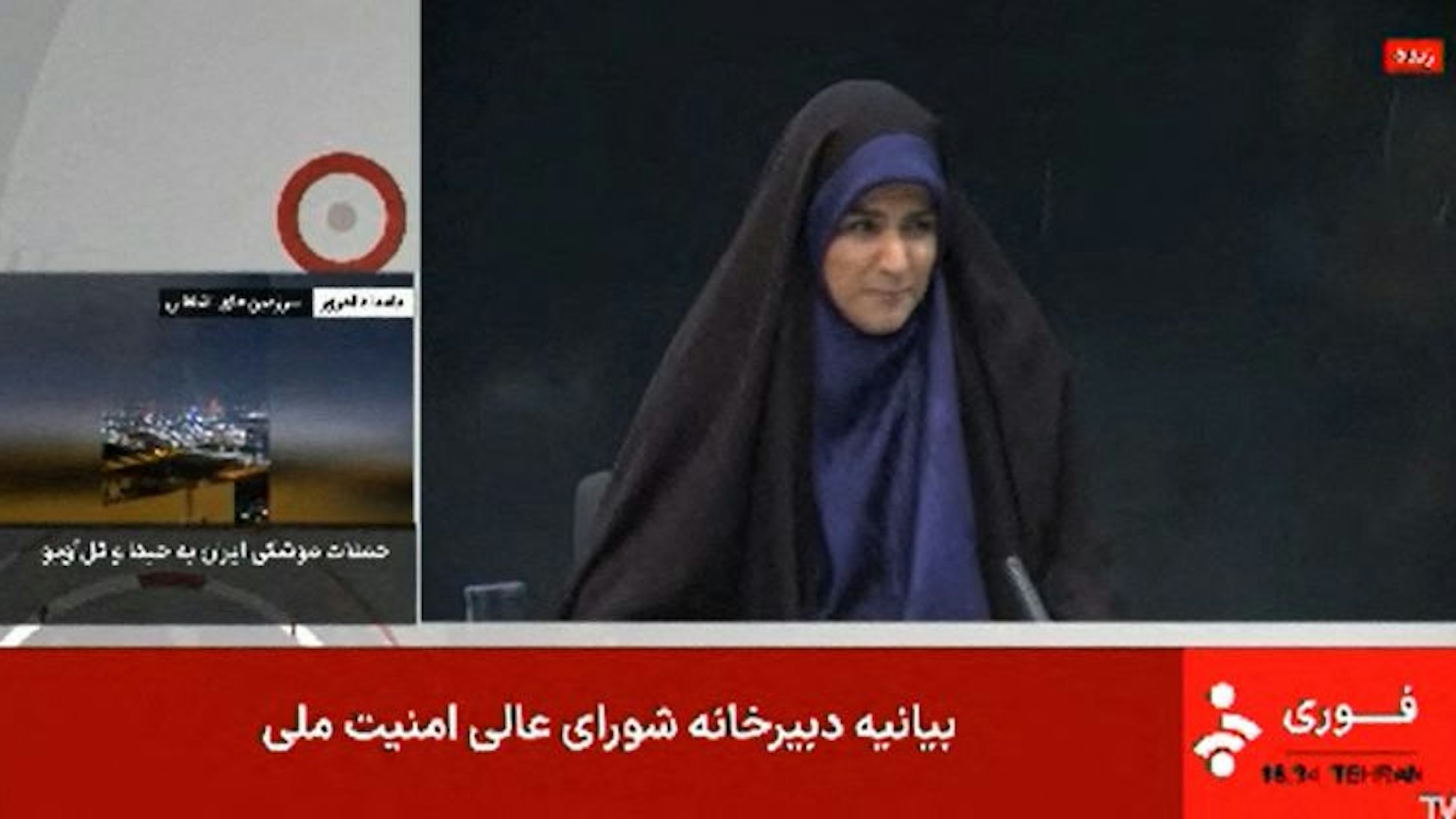 Dieses Bild, das aus Aufnahmen des iranischen Nachrichtensenders IRINN vom 16. Juni 2025 stammt, zeigt eine Reporterin, die nach einer lauten Explosion gestikuliert, während sie die Nachrichten präsentiert. Das Gebäude des Rundfunks der Islamischen Republik Iran (IRIB) wurde am 16. Juni bei einem israelischen Angriff getroffen und die Live-Berichterstattung sofort unterbrochen.