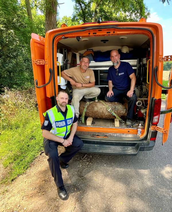 Drei Männer an einem Transporter.