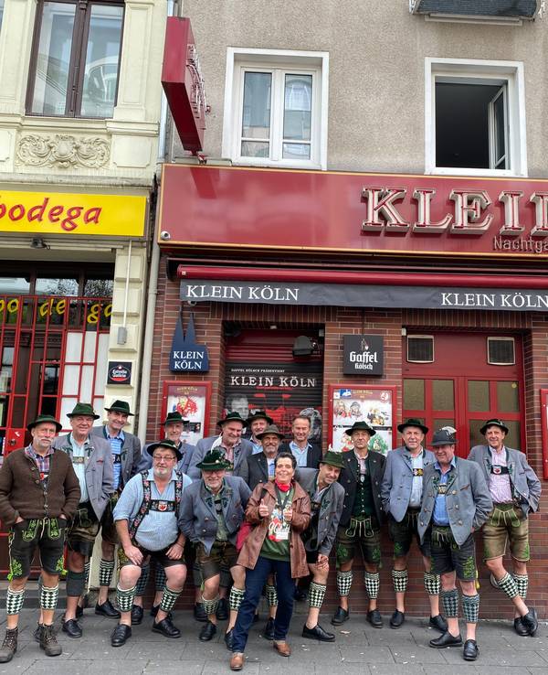 Eine Gruppe steht vor einer Kneipe.