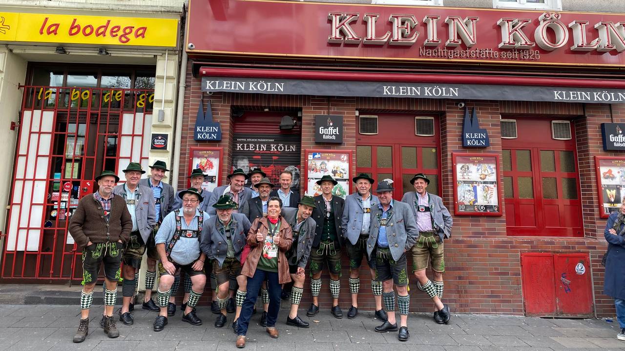 Eine Gruppe steht vor einer Kneipe.