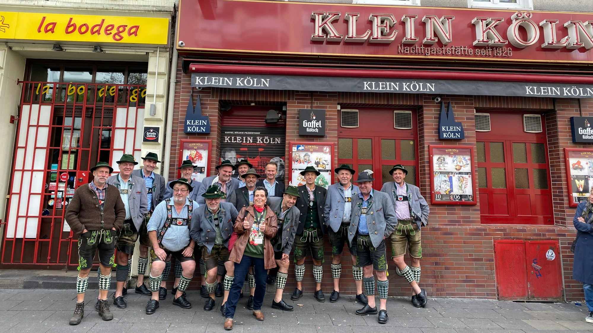 Eine Gruppe steht vor einer Kneipe.