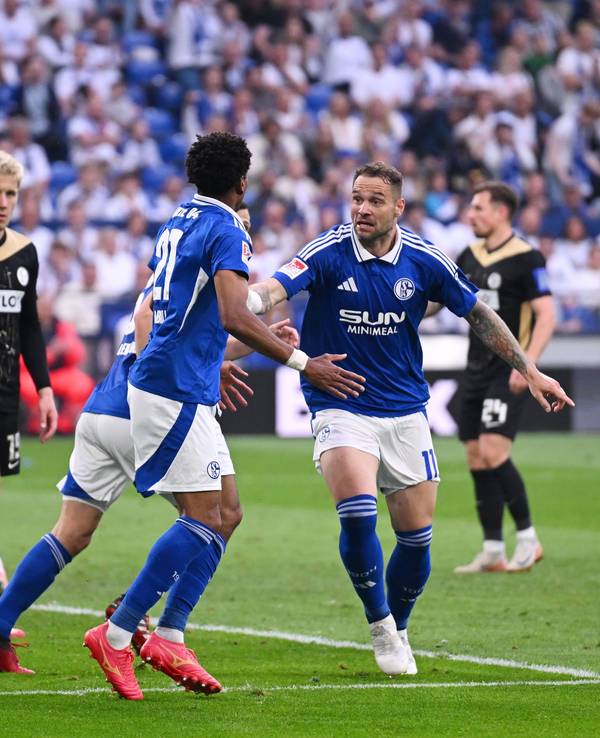 Schalkes Pierre-Michel Lasogga (M) spricht mit Yassin Ben Balla (3.v.l.) nach dessen Tor zum 1:2.