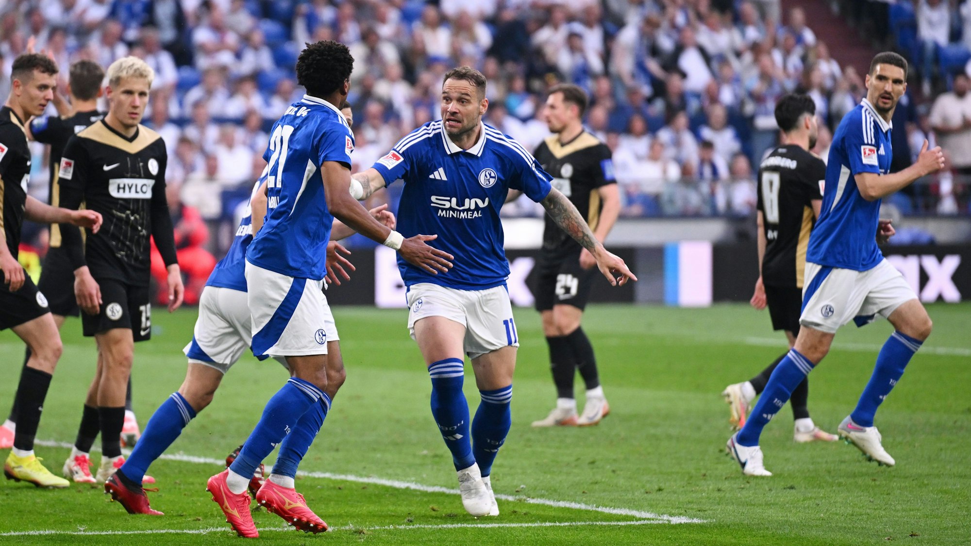 Schalkes Pierre-Michel Lasogga (M) spricht mit Yassin Ben Balla (3.v.l.) nach dessen Tor zum 1:2.