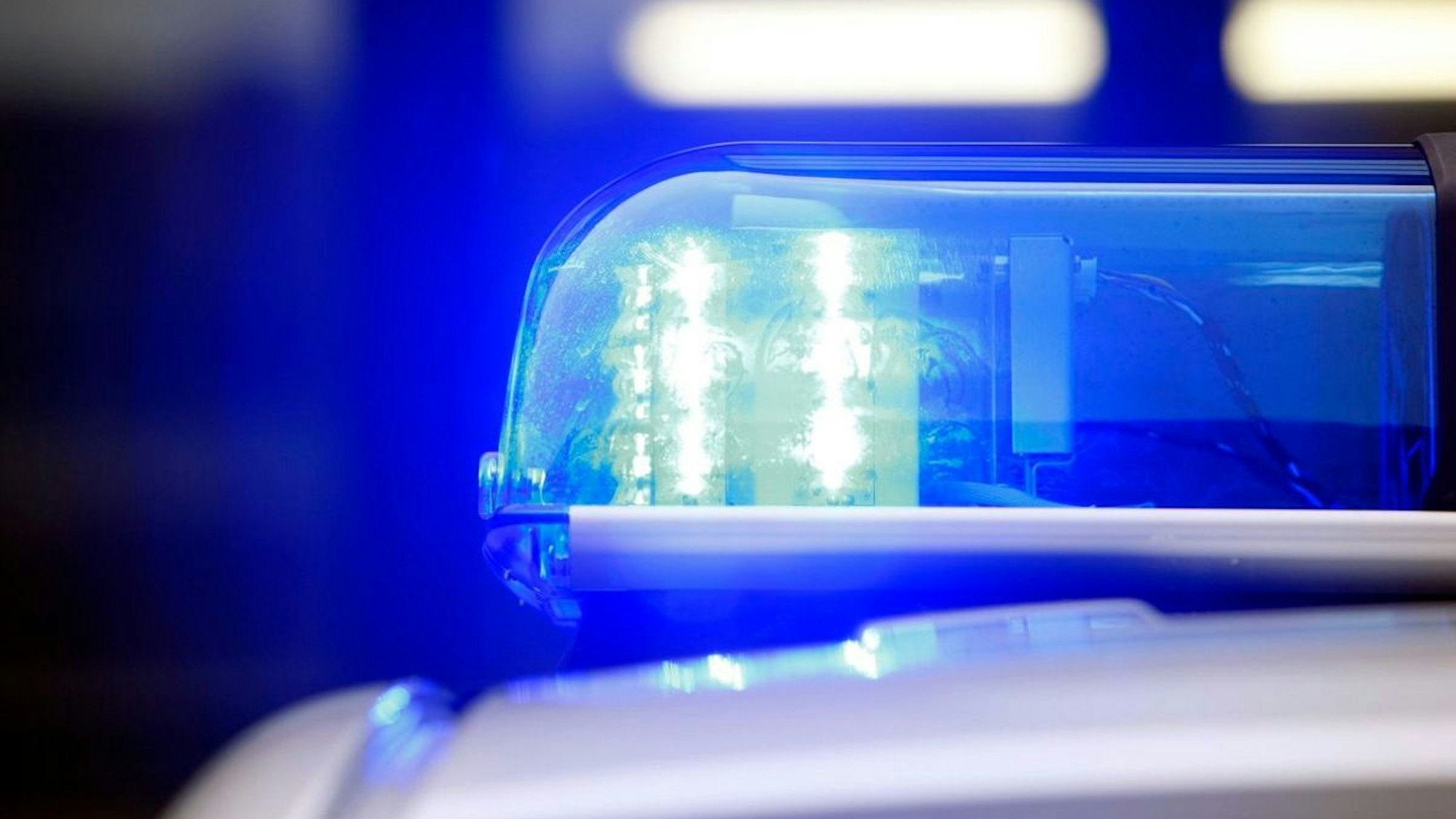 Symbolbild eines Polizeifahrzeugs mit Blaulicht im Tageslicht. In Velbert wurde ein 15-jähriger E-Scooter-Fahrer von zwei Jugendlichen angegriffen.