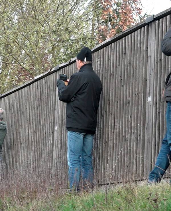 Gaffer fotografieren am 25. März 2019 neben einer Lärmschutzwand mit ihren Smartphones eine Unfallstelle.