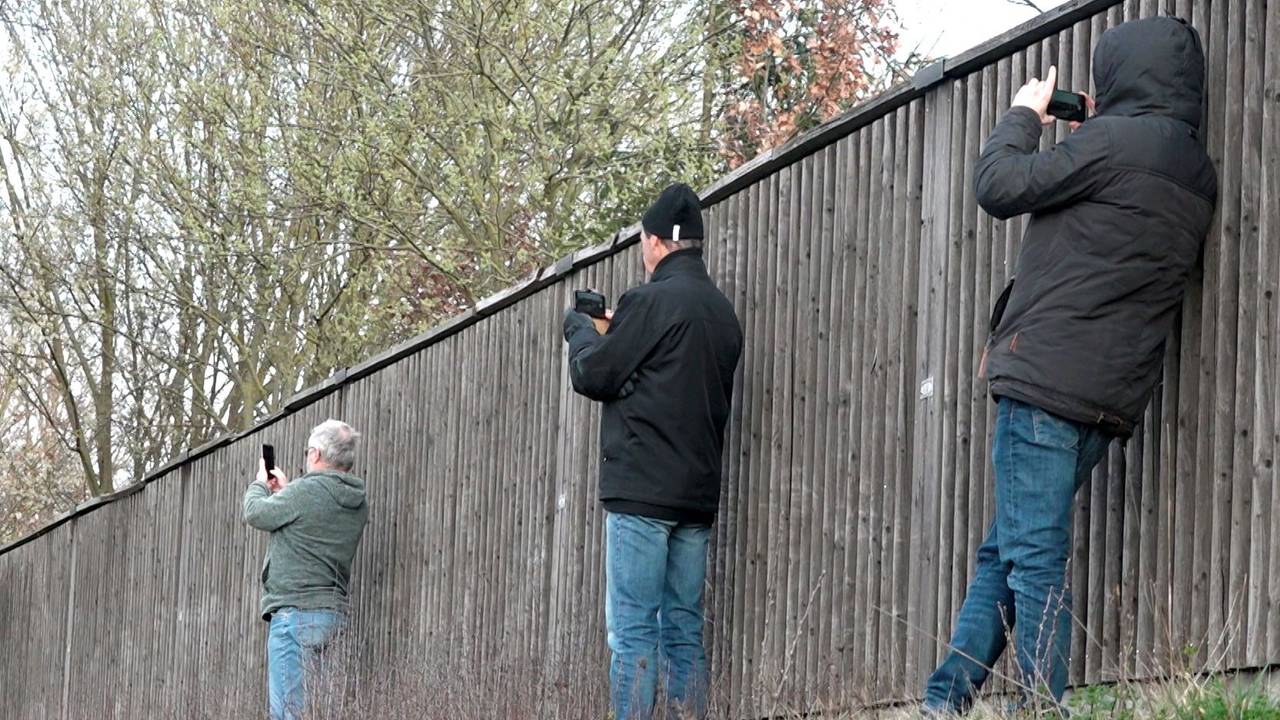 Gaffer fotografieren am 25. März 2019 neben einer Lärmschutzwand mit ihren Smartphones eine Unfallstelle.