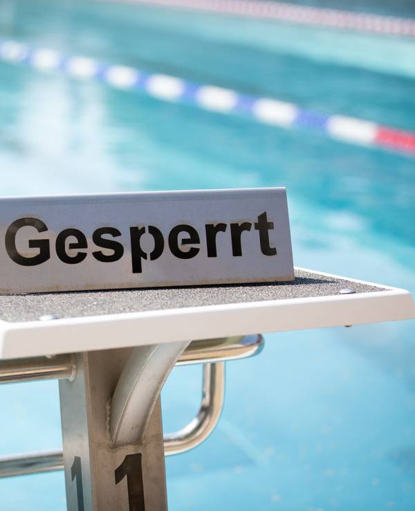 Ein "Gesperrt"-Schild steht auf einem Startblock in einem Schwimmbad. In einem Freibad in Inzell ist ein 15-jähriger Junge ums Leben gekommen.