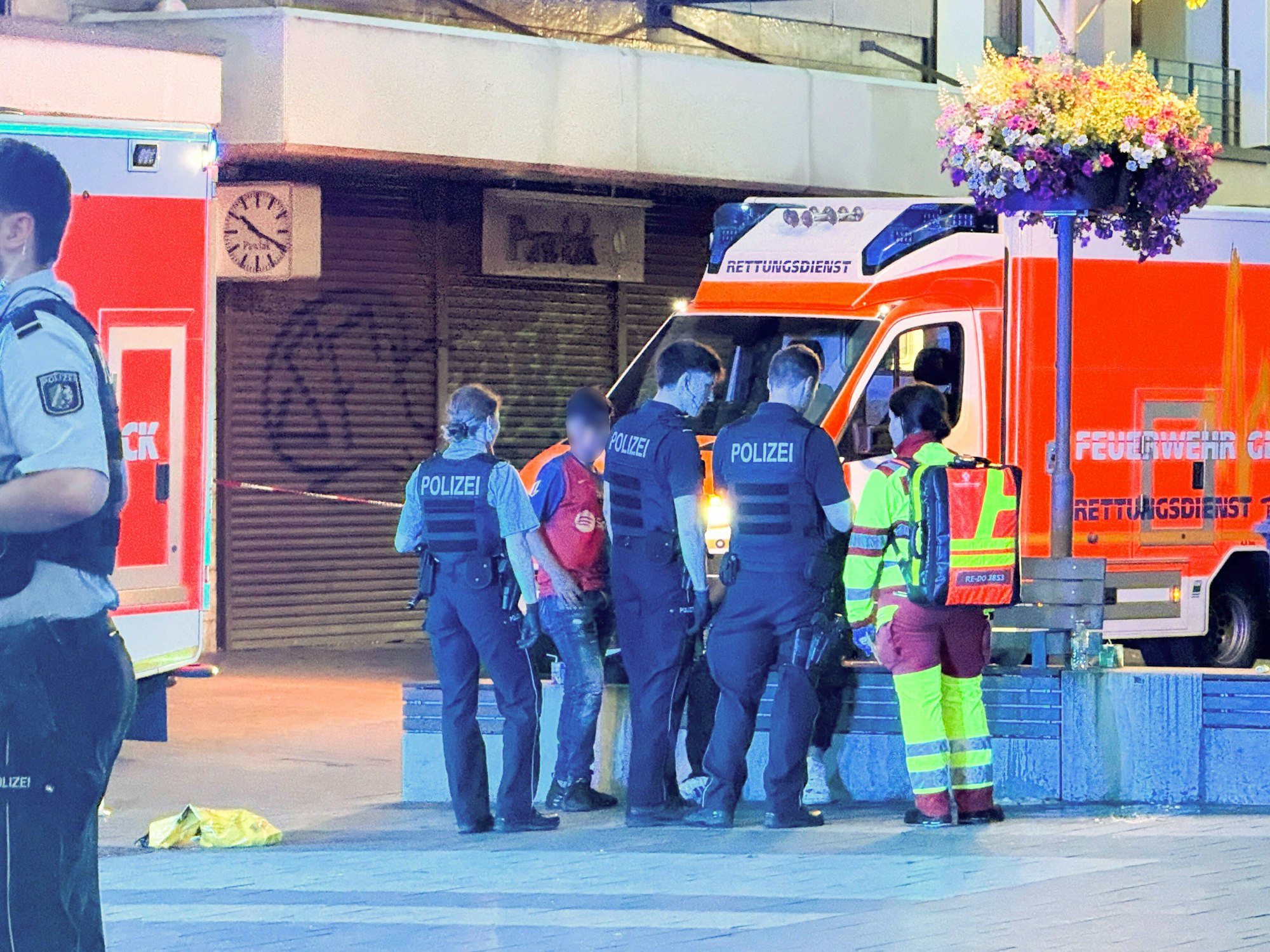 Einsatzkräfte der Polizei und Feuerwehr stehen vor einem Rettungswagen am Rande einer Schlägerei in der Innenstadt. Die Hintergründe des Streits unter Familienmitgliedern waren zunächst unklar.