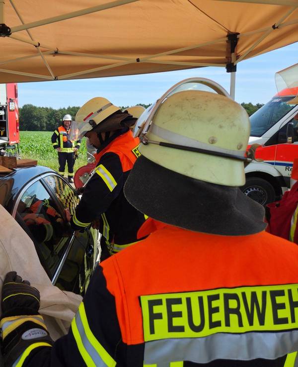 Mitarbeiter der Freiwillige Feuerwehren Visselhövede befreien die Kinder aus dem überhitzten Auto. Zuvor hatten die Einsatzkräfte ein schattenspendendes Zelt über dem Auto aufgebaut.
