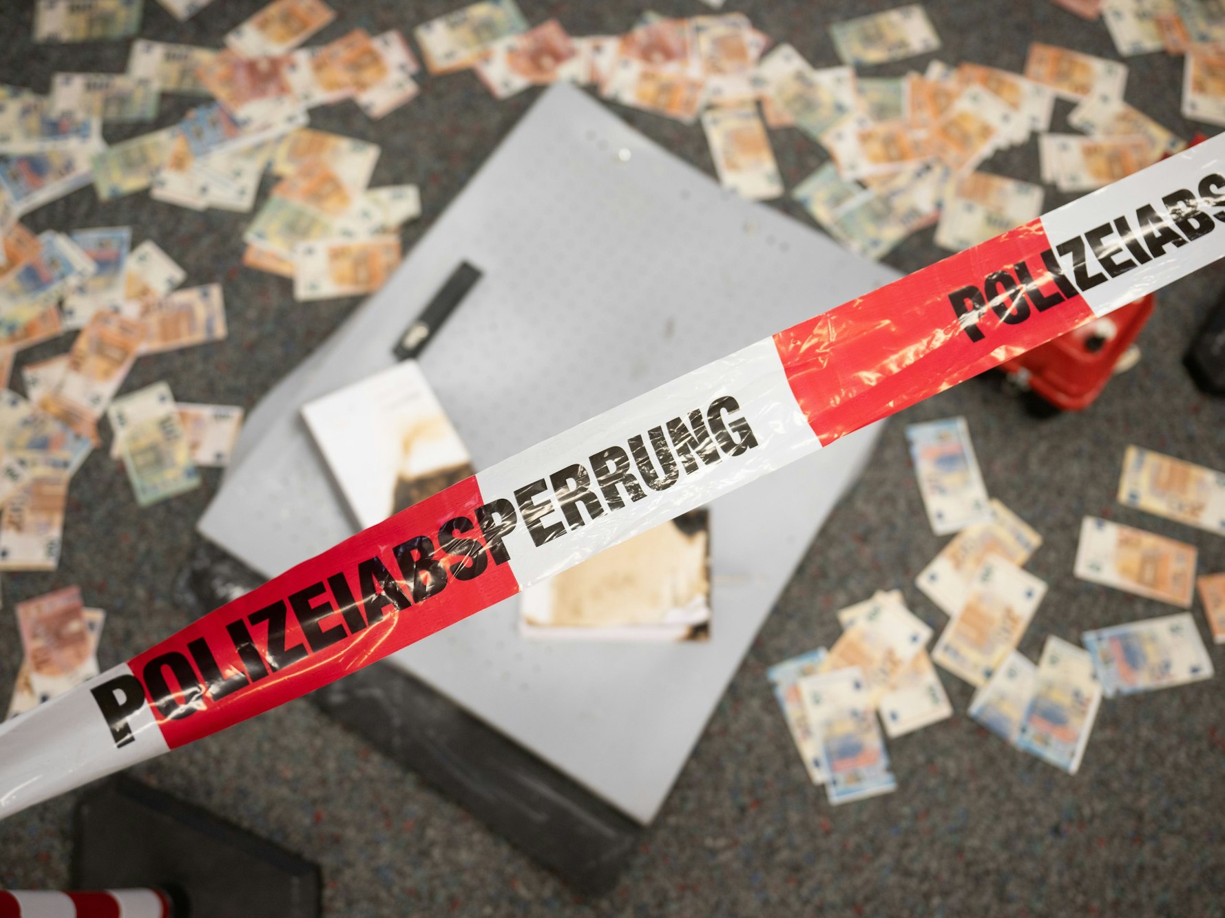 Das Symbolfoto zeigt Musterbanknoten, die während einer Pressekonferenz zum Kampf gegen Geldautomatensprengungen im Landeskriminalamt Hessen vor einem Geldautomat liegen, der zu Testzwecken durch das LKA gesprengt wurde.