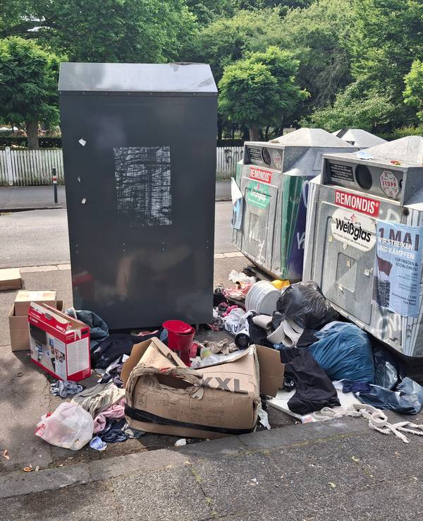 Müll liegt neben Containern.