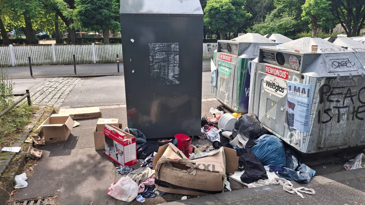 Müll liegt neben Containern.