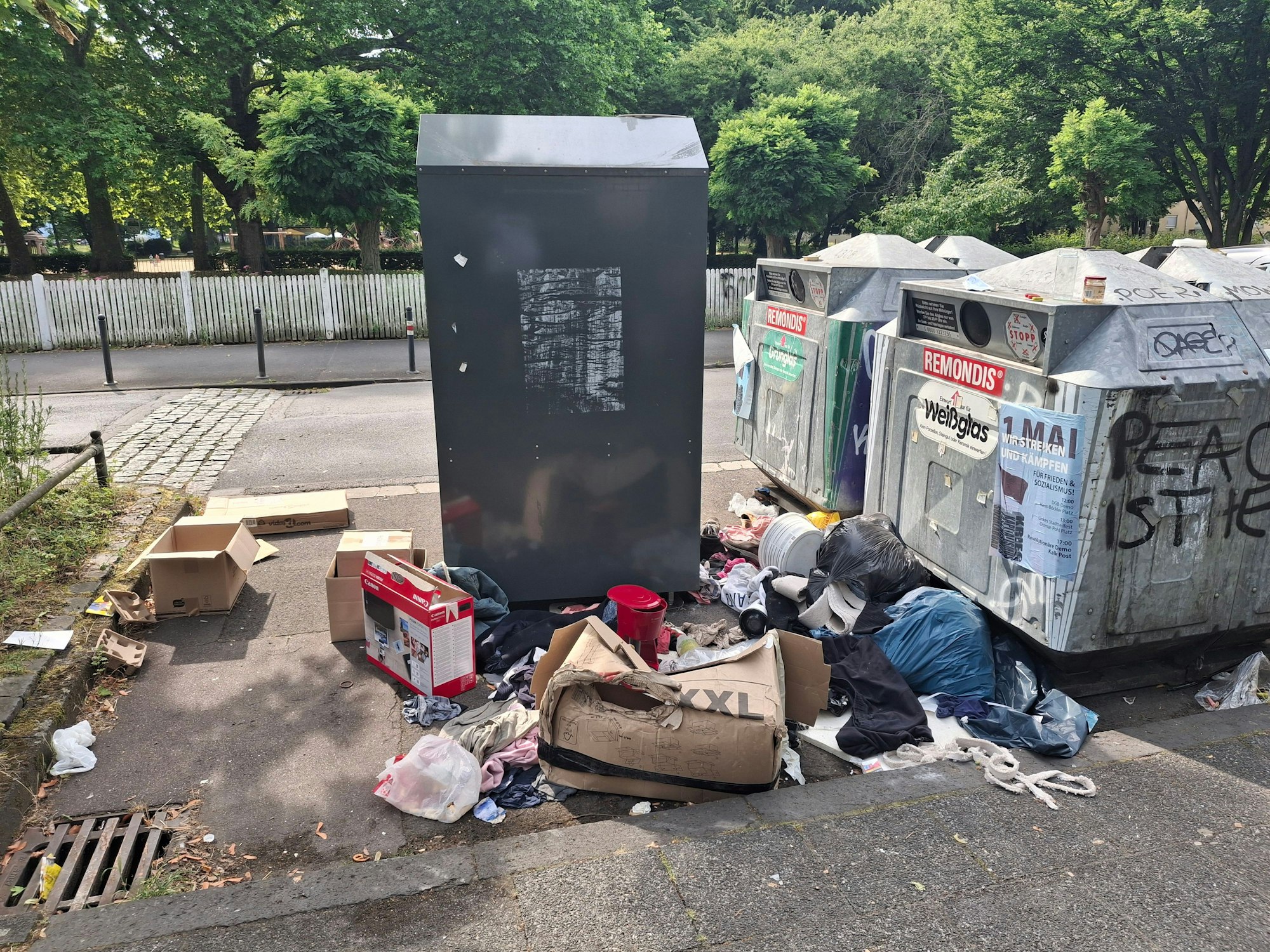 Müll liegt neben Containern.