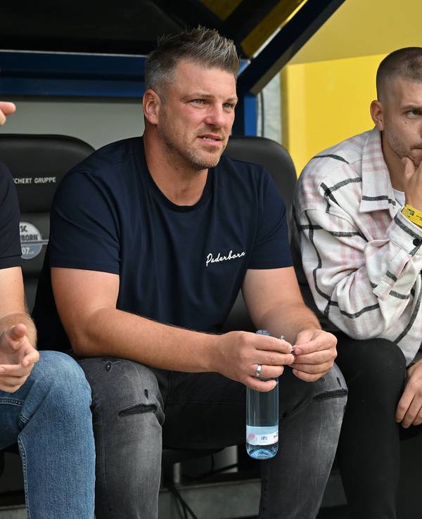Lukas Kwasniok sitzt zwischen Benjamin Weber und Robert Leipertz auf der Paderborner Ersatzbank.