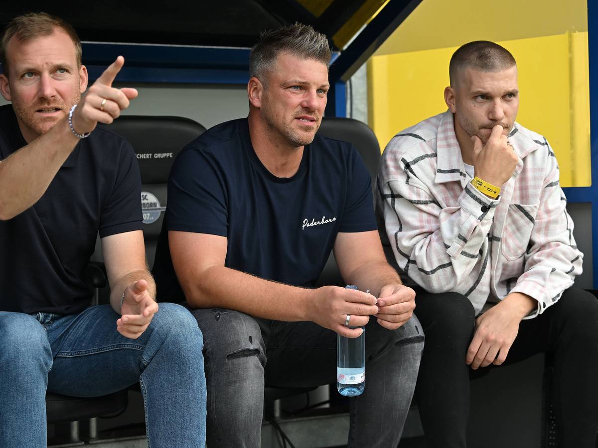 Lukas Kwasniok sitzt zwischen Benjamin Weber und Robert Leipertz auf der Paderborner Ersatzbank.