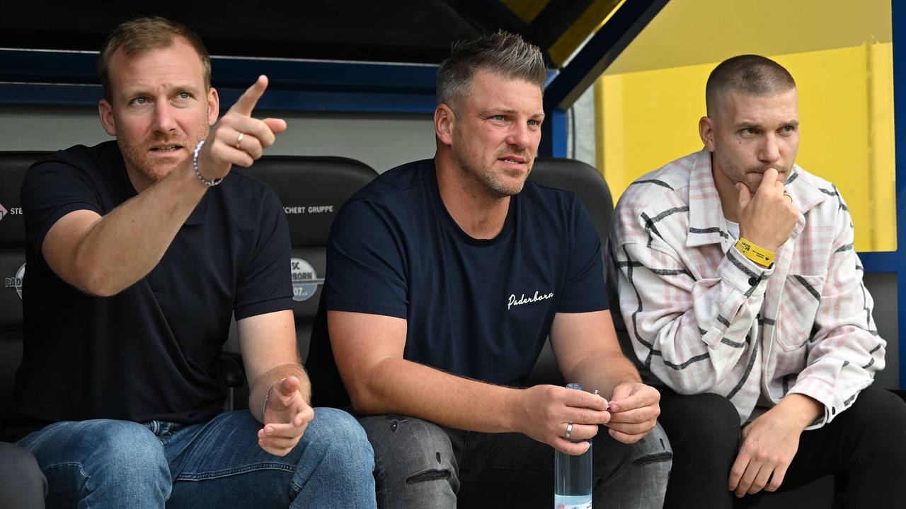 Lukas Kwasniok sitzt zwischen Benjamin Weber und Robert Leipertz auf der Paderborner Ersatzbank.