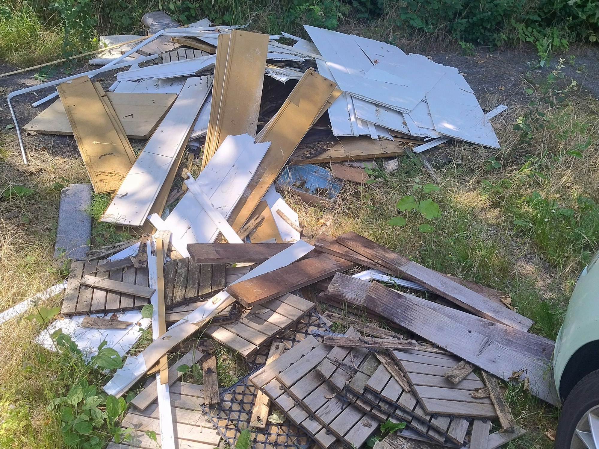 Holzlatten liegen auf einer Wiese.