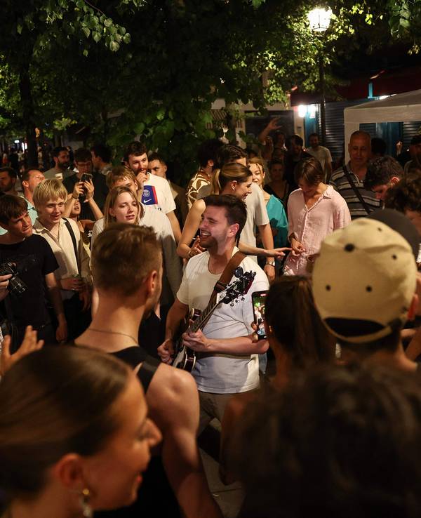 Musikbegeisterte lauschen einem Mann, der während des jährlichen französischen Straßenmusikfestivals "Fete de la Musique" im 4. Arrondissement von Paris Gitarre spielt.