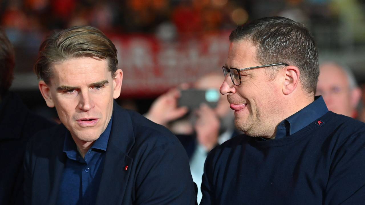 Max Eberl legt seine Oberlippe mit seiner Zunge ab, während er Christoph Freund anschaut.