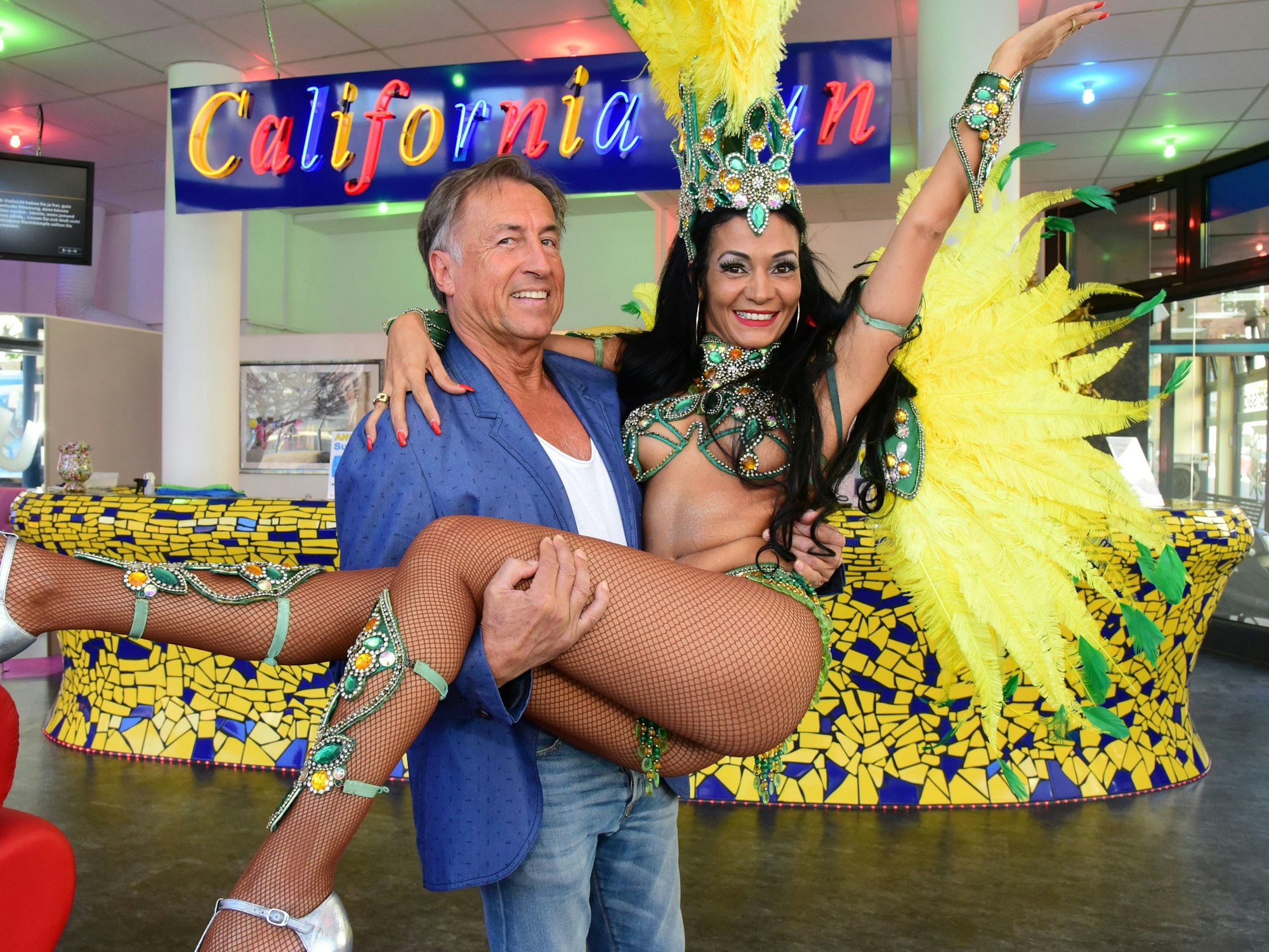 Ein Mann trägt eine leicht bekleidete Frau auf Händen.