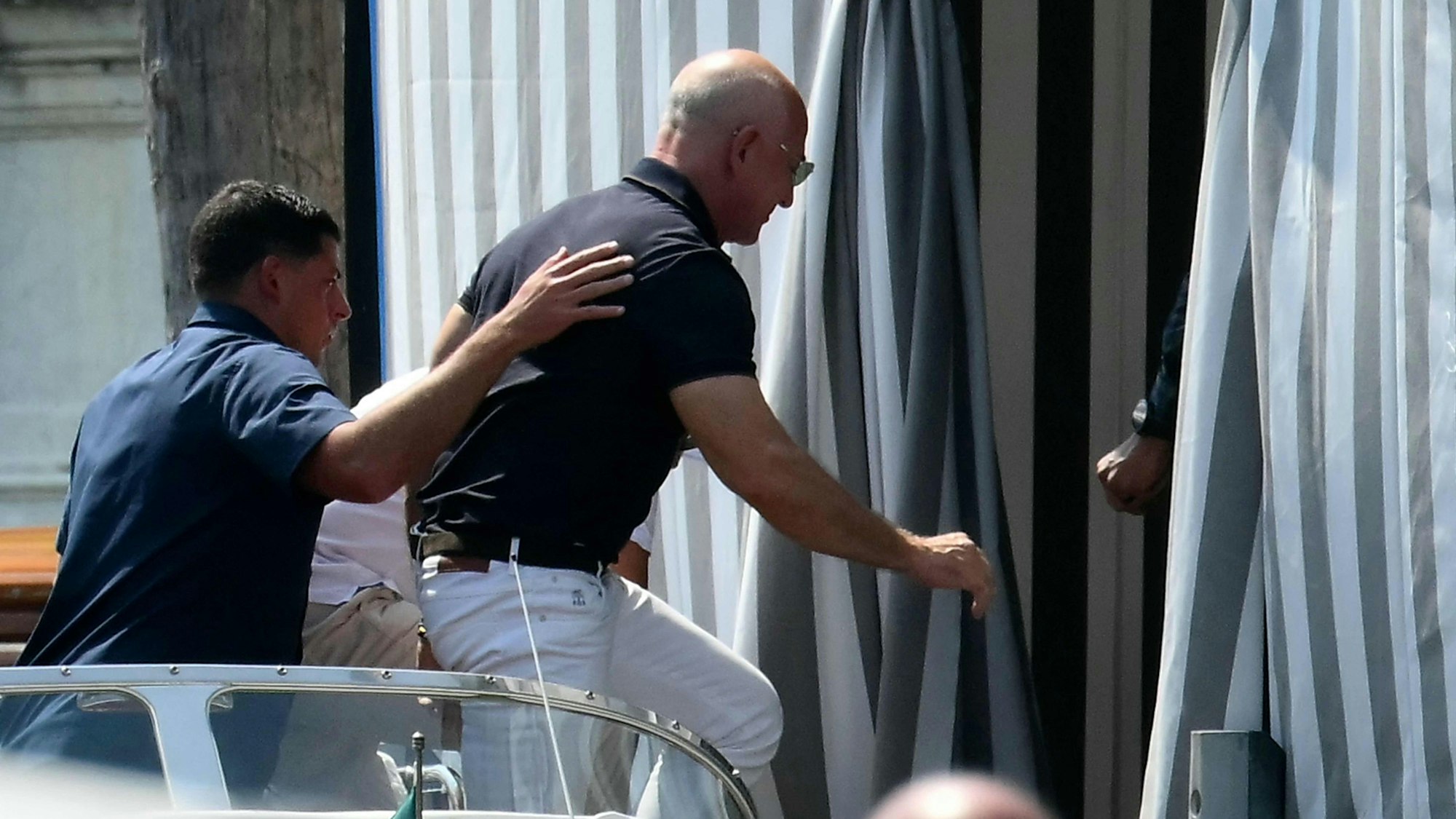 Jeff Bezos steigt aus einem Boot ins Aman-Hotel ein