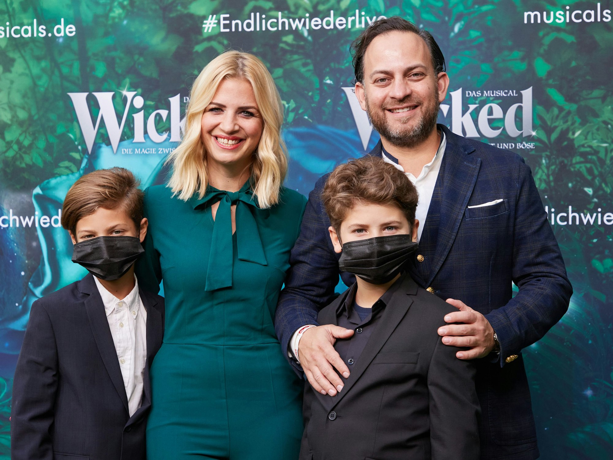 Susan Sideropoulos und ihre Familie bei einer Musicalveranstaltung. Die beiden Kinder tragen Corona-Masken.