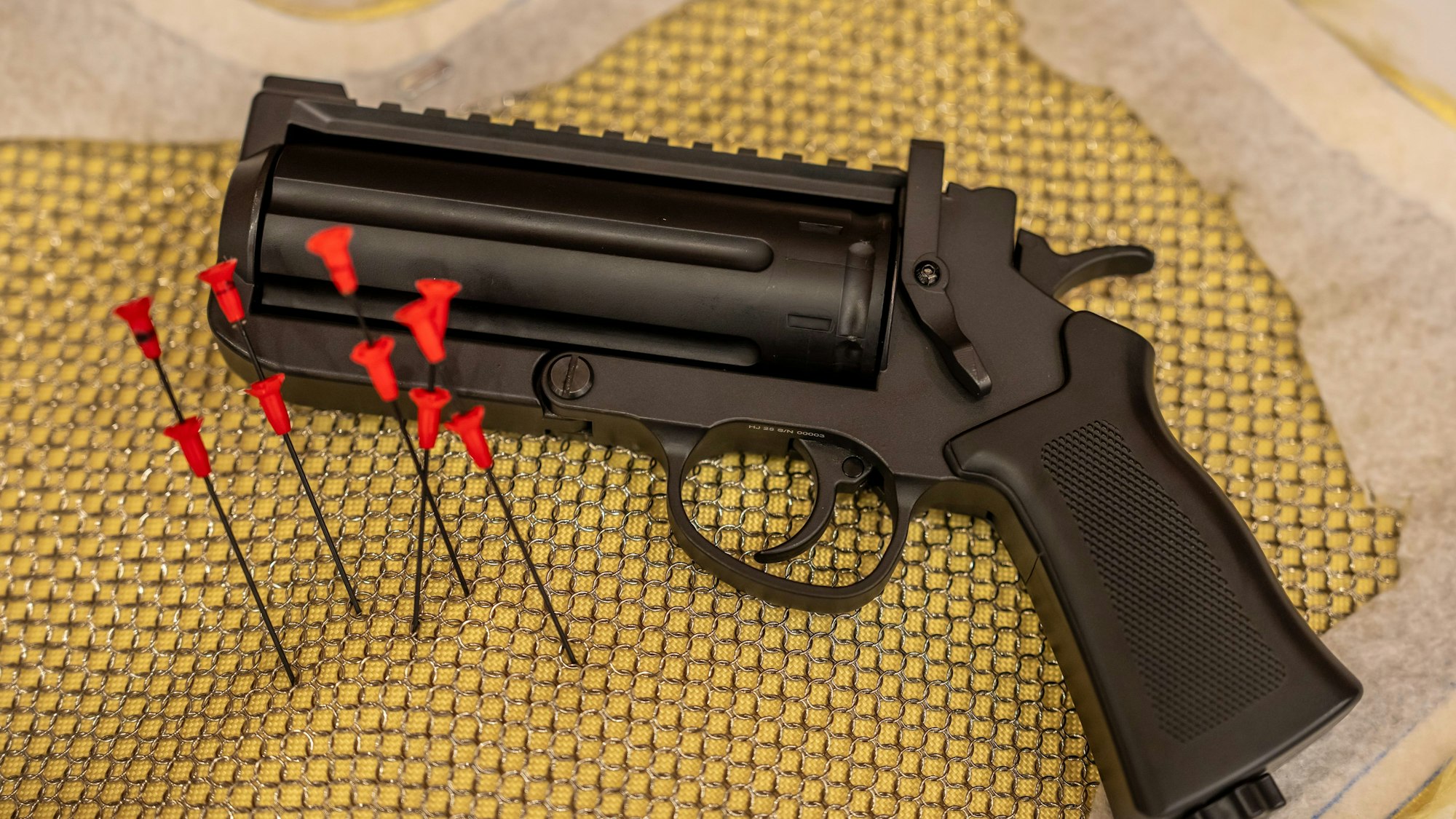 Eine neuartige Druckluftpistole, die Nadeln verschießt und die künftig verboten werden soll, ist bei einer Vorführung im Innenministerium zu sehen.