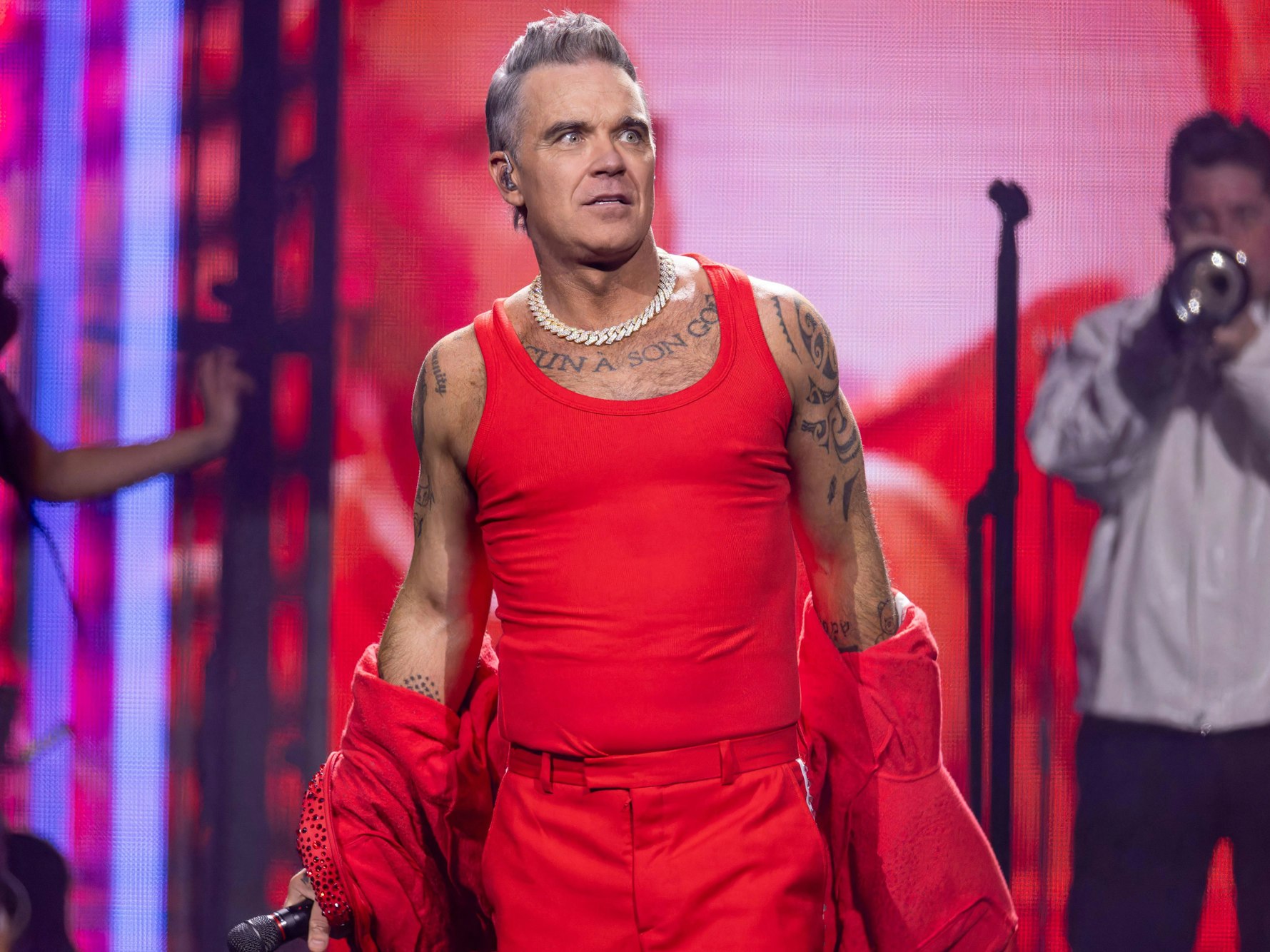 Robbie Williams im roten Unterhemd auf der Bühne.