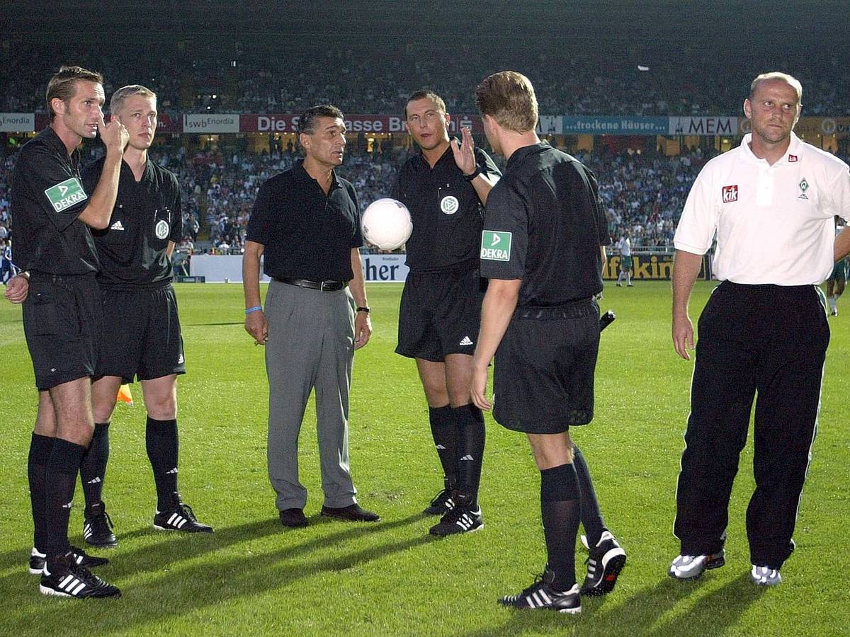 Rudi Assauer muss sich während des Stromausfalls in Bremen im August 2004 beim Schiedsrichtergespann erkundigen.