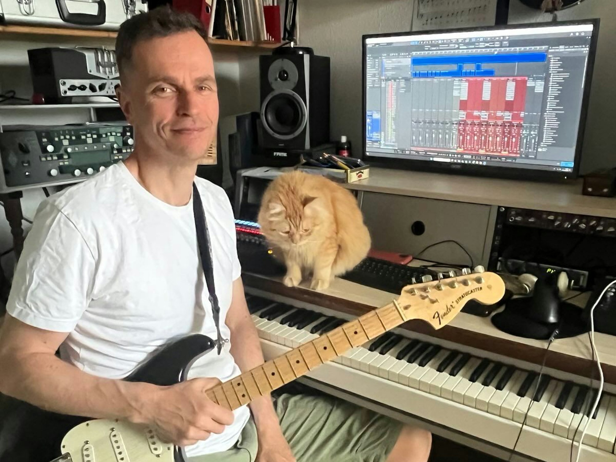 Frank Hartmann sitzt mit Gitarre im Studio.