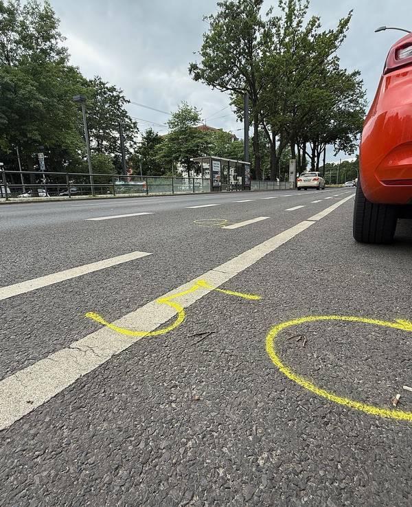 Kreide, aufgezeichnet von der Polizei, zeigen auf der Straße an der Wuhlheide Fundorte von Spuren nach einem tödlichen Verkehrsunfall.