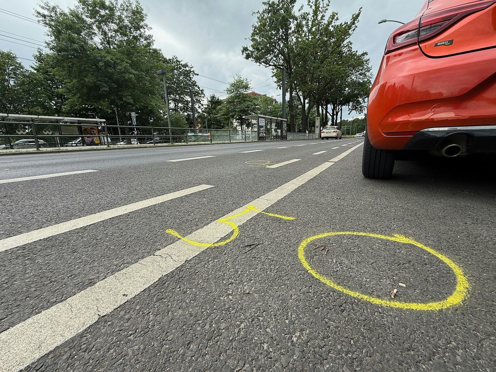 Kreide, aufgezeichnet von der Polizei, zeigen auf der Straße an der Wuhlheide Fundorte von Spuren nach einem tödlichen Verkehrsunfall.