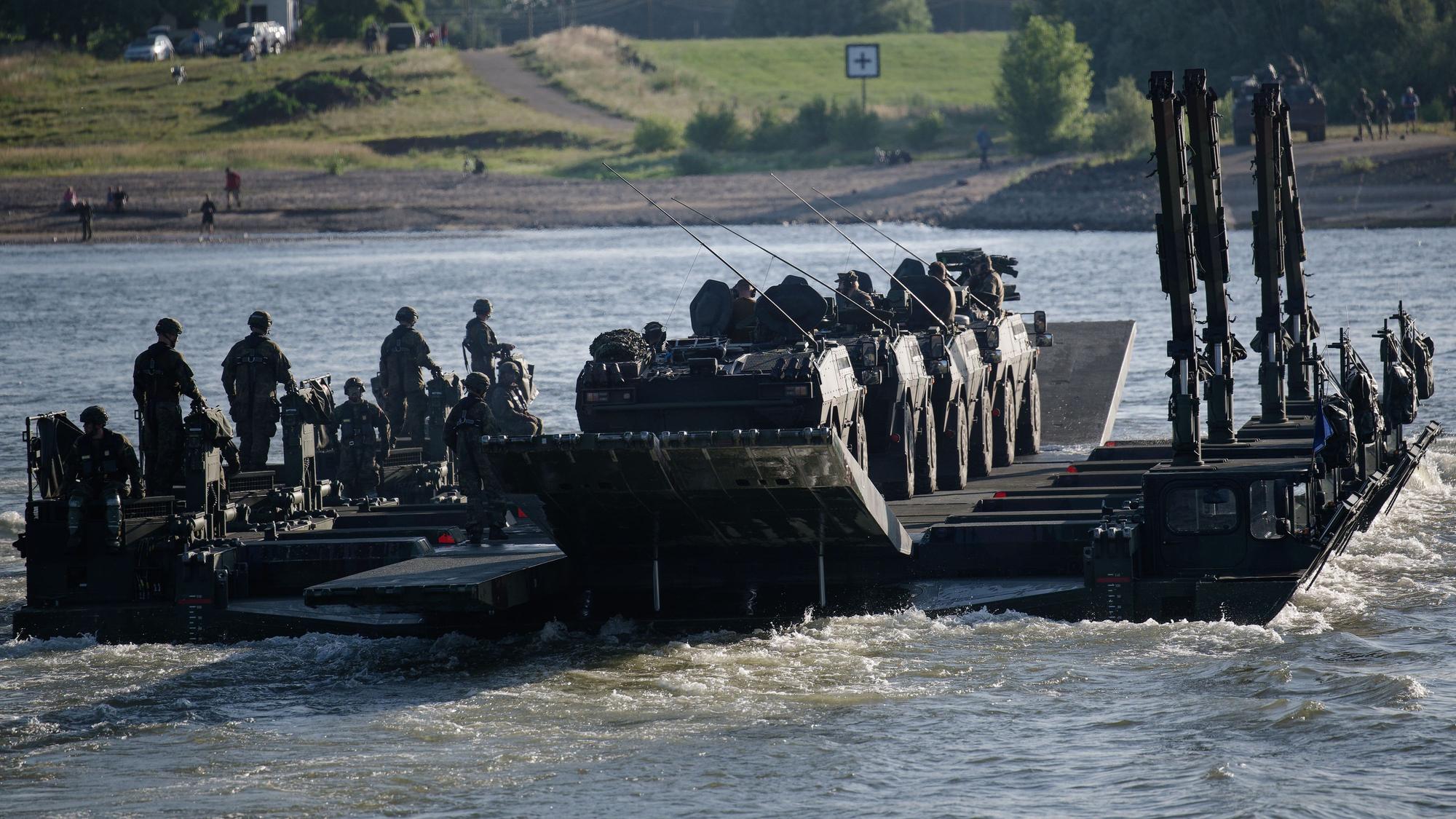 Eine aus Amphibienfahrzeugen gebildete Fähre transportiert Fahrzeuge im Rahmen der Übung „Grand Crossing“ über den Rhein.
