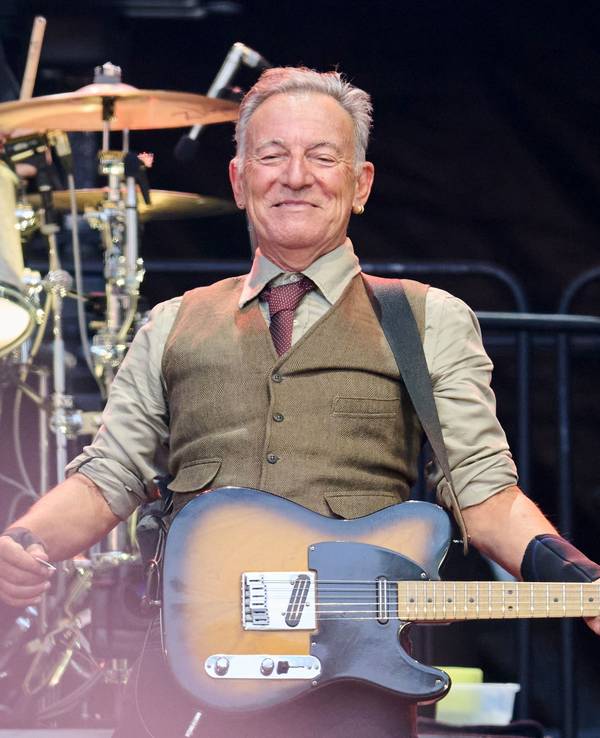 Bruce Springsteen steht mit Gitarre auf der Bühne.