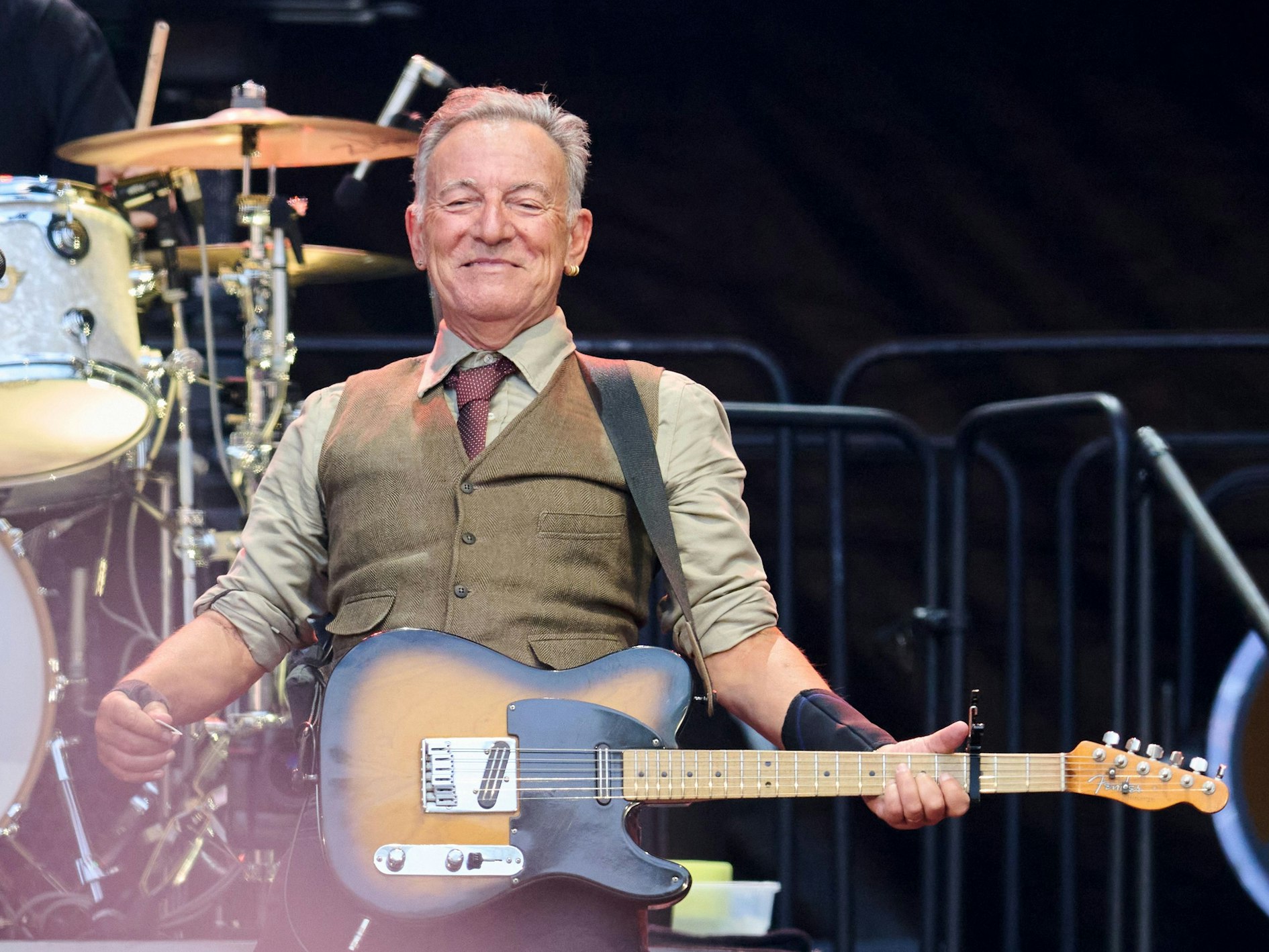 Bruce Springsteen steht mit Gitarre auf der Bühne.