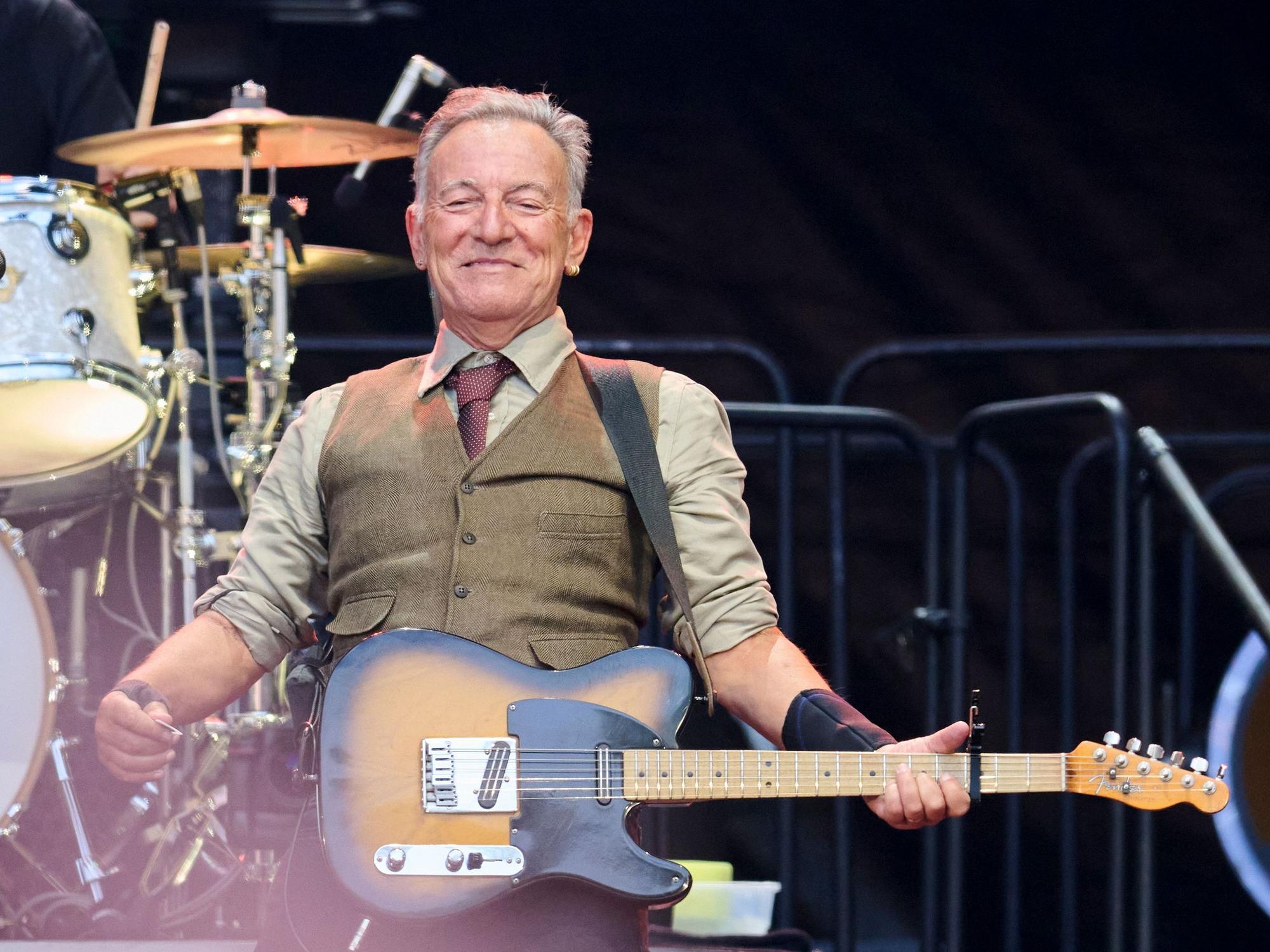 Bruce Springsteen steht mit Gitarre auf der Bühne.