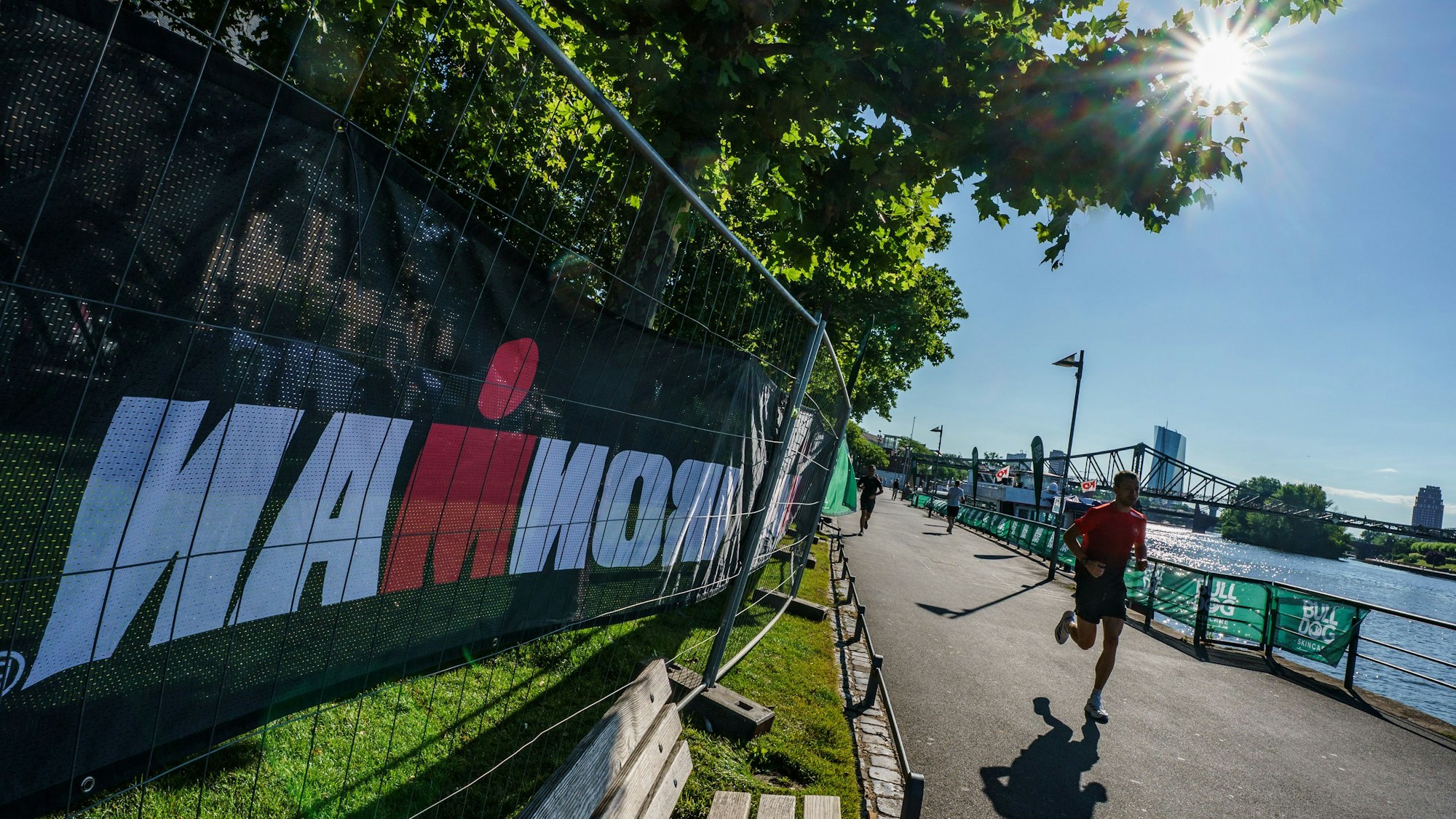 Ein Mann joggt in Frankfurt/Main am Mainufer vorbei.