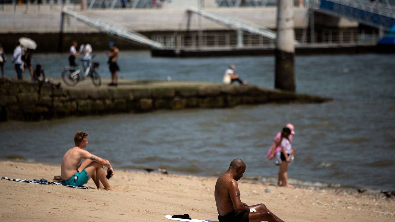 Menschen sonnen sich während der Hitzewelle in Lissabon am 29. Juni 2025 am Fluss Tajo.