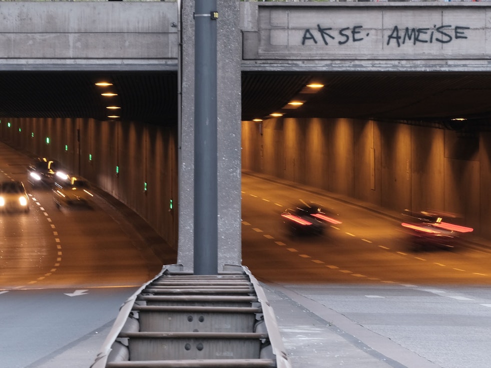 Autos fahren in den Rheinufertunnel hinein und hinaus.
